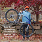 Person holding a bicycle with text about its strength in an outdoor setting.